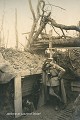 Officier et soldat allemands à l’entrée d’un abri souterrain s’ouvrant dans la paroi d’une tranchée à Hartmannswillerkopf (Vieil Armand en Français) non loin de Mulhouse, au printemps 1916. Comme l’indique le panonceau, ce « Fuchsbau » (terrier), était pourvu de 2 sorties et pouvait accueillir 22 hommes (France, Première Guerre mondiale). Photographie : Hans Hildenbrand - collection Noëlle et Jean-Noël Deletang. 14-18 
 1916 
 Fuchsbau 
 Hartmannswillerkopf 
 Vieil Armand 
 allemands 
 première guerre mondiale 
 souterrain 
 tunnel 