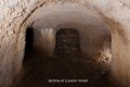 Les salles de ce souterrain creusé sous un « ringfort » daté du XIe-XIIe siècle sont disposées autour d’un puits d’extraction comblé tout en préservant des tuyaux d’aération. Ce souterrain a été reconstitué après une fouille exhaustive du site ; souterrain de Lisnagun (comté de Cork, Irlande). Irlande 
 Lisnagun 
 Moyen Age 
 enceinte circulaire 
 forteresse médiévale 
 fortification 
 ringfort 
 souterrain 
 souterrain aménagé 
 souterrain-refuge 