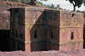 La partie haute de Bete Giorghis (l’église de saint Georges) émerge du plateau dans lequel elle a été creusée. Les fenêtres, ornées au deuxième niveau de croix à demi-palmettes, éclairent une salle unique cruciforme (Lalibela, Ethiopie). Abyssinie 
 Bete Giorghis 
 Ethiopie 
 Lalibela 
 UNESCO 
 christianisme 
 chrétiens 
 grotte 
 sanctuaire 
 troglodyte 
 tuf volcanique 
 église monolithe 
 église souterraine 
