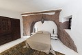 Dans cette pièce à moitié creusée, la roche brute est mise en valeur par les parois chaulées qui l’entourent ; Lagomar, village de Nazaret (Lanzarote, Canaries). Canaries 
 Lagomar 
 Lanzarote 
 Nazaret 
 architecture rupestre 
 artiste 
 maison troglodytique 
 troglodyte 
 volcanique 